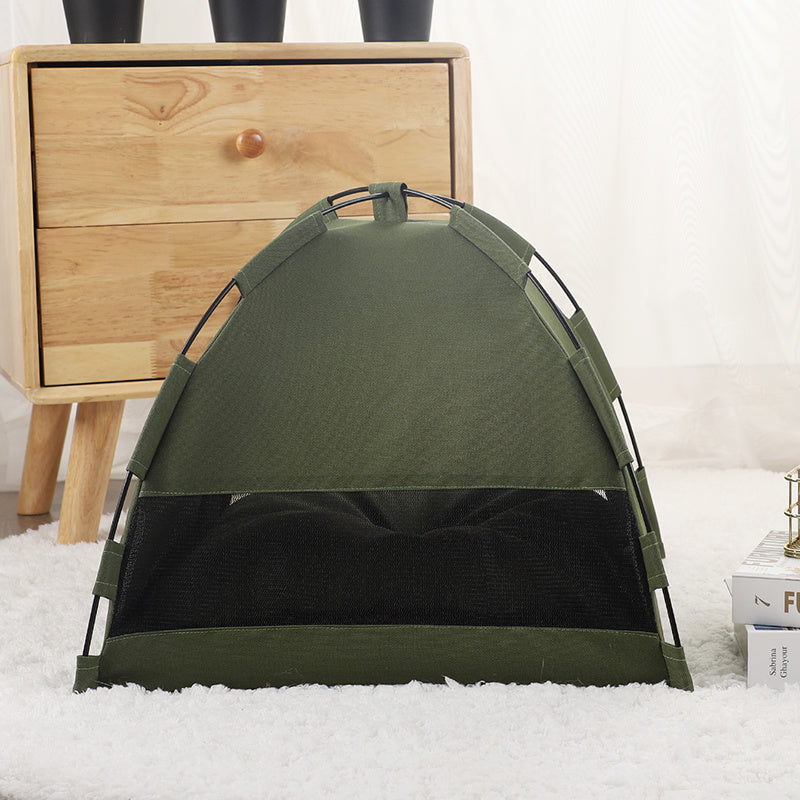 Military green portable cat tent and cooling mat pet bed set up indoors on white carpet near wooden drawer unit