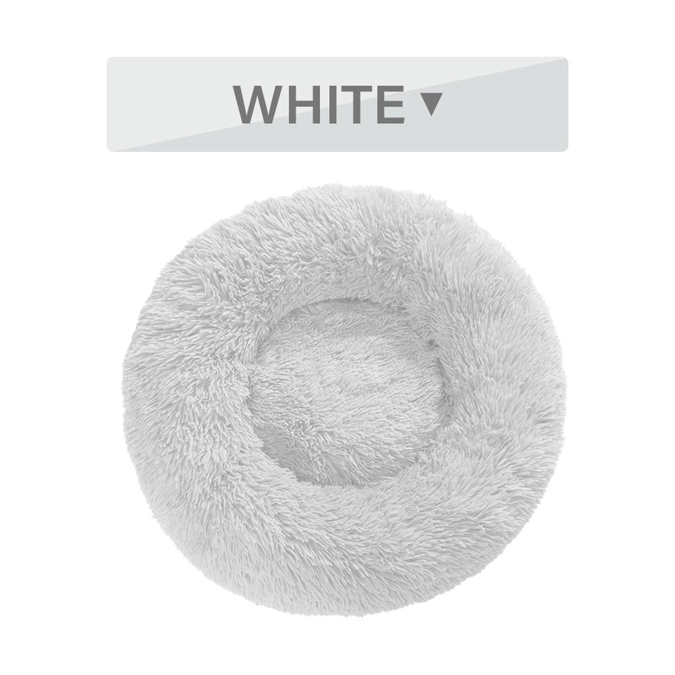 White fluffy donut dog bed with ultra-plush, calming design for cats and dogs, featuring raised rim and soft long plush texture.
