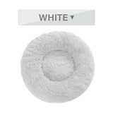 White fluffy donut dog bed with ultra-plush, calming design for cats and dogs, featuring raised rim and soft long plush texture.