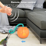 Electric pumpkin-shaped cat toy with feather attachment and remote voice control on floor near gray sofa
